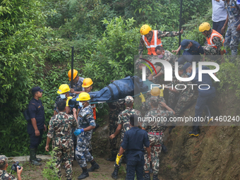 Nepali security forces are carrying the bodies of victims to the hearse from the site of the crashed Air Dynasty Helicopter in Nuwakot Distr...