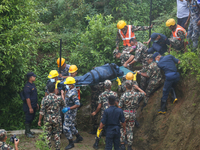 Nepali security forces are carrying the bodies of victims to the hearse from the site of the crashed Air Dynasty Helicopter in Nuwakot Distr...