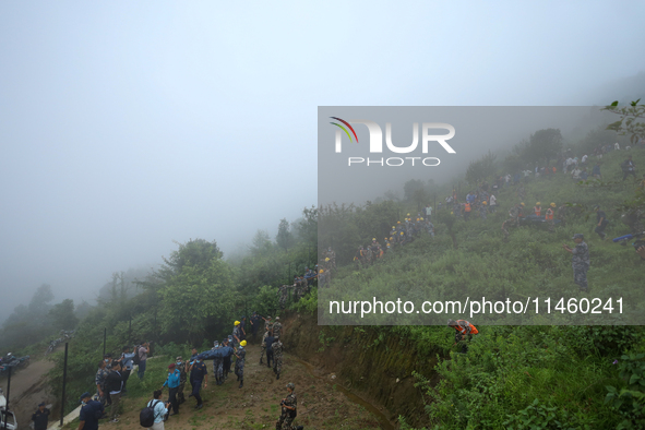 Nepali security forces are carrying the bodies of victims to the hearse from the site of the crashed Air Dynasty Helicopter in Nuwakot Distr...