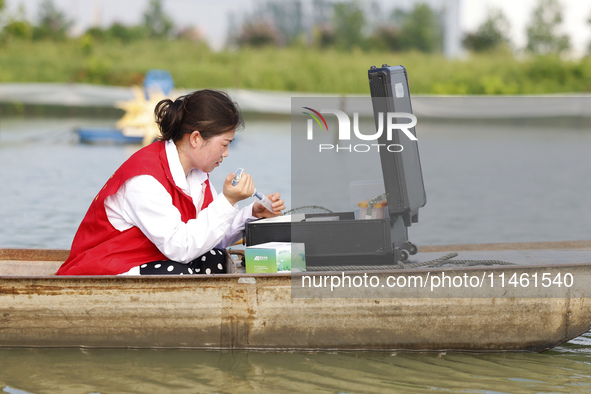 Aquaculture technicians are testing water quality at a crab pond in Wanggou village in Suqian, Jiangsu province, China, on August 7, 2024. 