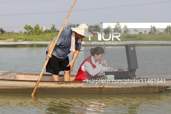 Aquaculture technicians are testing water quality at a crab pond in Wanggou village in Suqian, Jiangsu province, China, on August 7, 2024. 