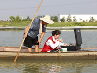 Aquaculture technicians are testing water quality at a crab pond in Wanggou village in Suqian, Jiangsu province, China, on August 7, 2024. (