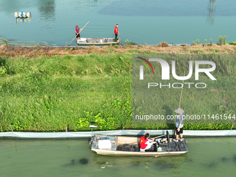 Aquaculture technicians are testing water quality at a crab pond in Wanggou village in Suqian, Jiangsu province, China, on August 7, 2024. (