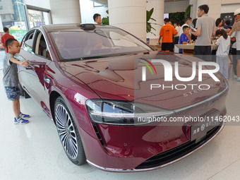 People are experiencing the HIMA S9 new electric sedan at the Huawei Store in Wangfujing in Beijing, China, on August 8, 2024. (