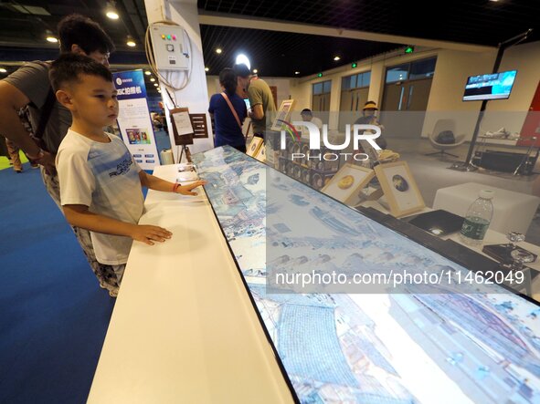 A child is visiting ''Riverside Scene at Qingming Festival'' at the first Beijing International Science Festival in Beijing, China, on Augus...