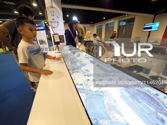 A child is visiting ''Riverside Scene at Qingming Festival'' at the first Beijing International Science Festival in Beijing, China, on Augus...