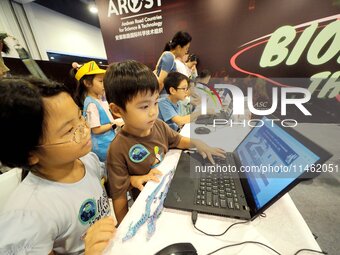 A child is playing a popular science interactive computer game at the first Beijing International Science Festival in Beijing, China, on Aug...