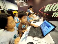 A child is playing a popular science interactive computer game at the first Beijing International Science Festival in Beijing, China, on Aug...