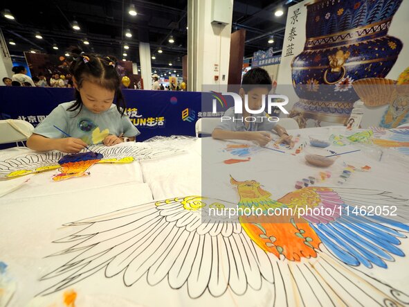 A child is experiencing ''kite painting'' at the first Beijing International Science Festival in Beijing, China, on August 8, 2024. 