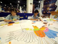 A child is experiencing ''kite painting'' at the first Beijing International Science Festival in Beijing, China, on August 8, 2024. (