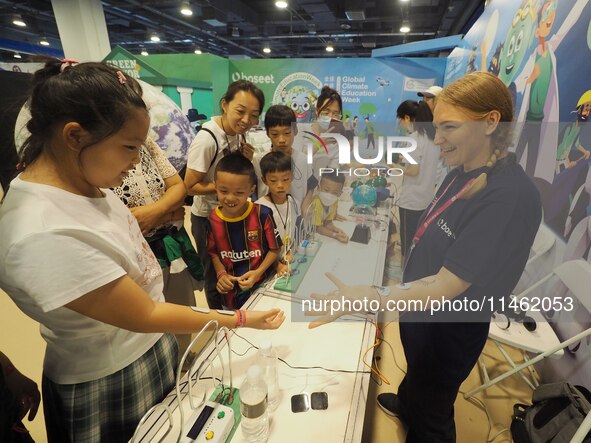 A child is experiencing a ''current conduction experiment'' at the first Beijing International Science Festival in Beijing, China, on August...