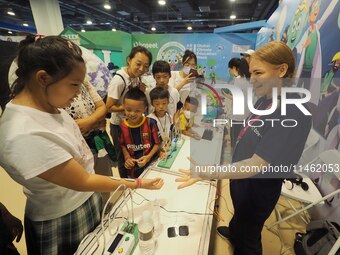 A child is experiencing a ''current conduction experiment'' at the first Beijing International Science Festival in Beijing, China, on August...