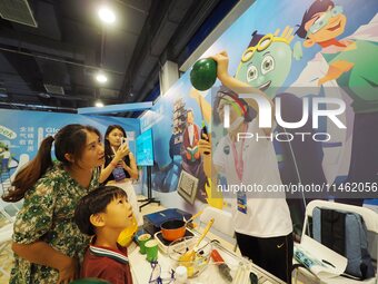 A child is experiencing the ''balloon heating experiment'' at the first Beijing International Science Festival in Beijing, China, on August...