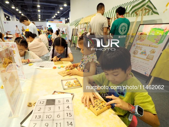 A child is experiencing an ''intellectual toy'' at the first Beijing International Science Festival in Beijing, China, on August 8, 2024. 