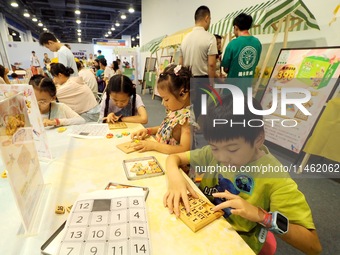 A child is experiencing an ''intellectual toy'' at the first Beijing International Science Festival in Beijing, China, on August 8, 2024. (