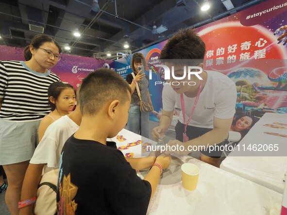 A child is experiencing the ''thermal expansion and cold contraction experiment'' at the first Beijing International Science Festival in Bei...