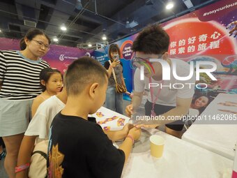 A child is experiencing the ''thermal expansion and cold contraction experiment'' at the first Beijing International Science Festival in Bei...