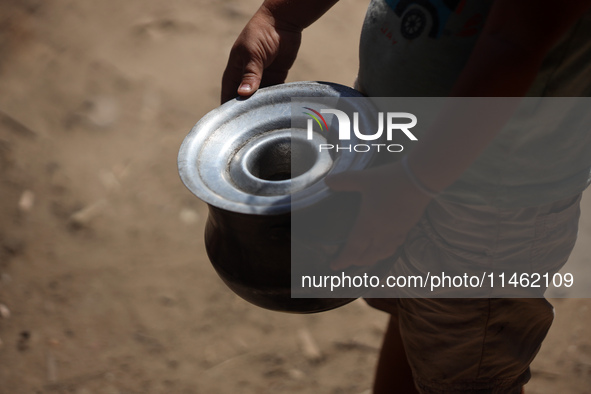 A Palestinian is carrying food cooked by a charity kitchen, amid shortages of aid supplies, as the conflict between Israel and Hamas continu...