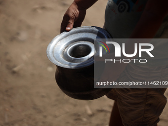 A Palestinian is carrying food cooked by a charity kitchen, amid shortages of aid supplies, as the conflict between Israel and Hamas continu...