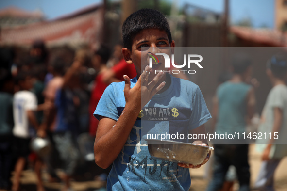 A Palestinian is carrying food cooked by a charity kitchen, amid shortages of aid supplies, as the conflict between Israel and Hamas continu...