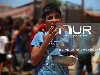 A Palestinian is carrying food cooked by a charity kitchen, amid shortages of aid supplies, as the conflict between Israel and Hamas continu...