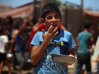 A Palestinian is carrying food cooked by a charity kitchen, amid shortages of aid supplies, as the conflict between Israel and Hamas continu...