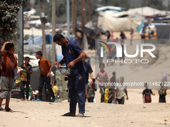 A Palestinian is carrying food cooked by a charity kitchen, amid shortages of aid supplies, as the conflict between Israel and Hamas continu...