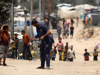 A Palestinian is carrying food cooked by a charity kitchen, amid shortages of aid supplies, as the conflict between Israel and Hamas continu...