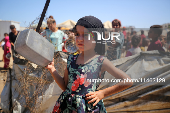 Displaced Palestinians are gathering to receive food cooked by a charity kitchen, amid food scarcity, as the Israel-Hamas conflict continues...