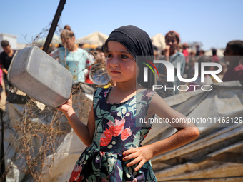 Displaced Palestinians are gathering to receive food cooked by a charity kitchen, amid food scarcity, as the Israel-Hamas conflict continues...