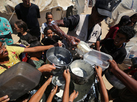 Displaced Palestinians are gathering to receive food cooked by a charity kitchen, amid food scarcity, as the Israel-Hamas conflict continues...