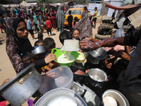 Displaced Palestinians are gathering to receive food cooked by a charity kitchen, amid food scarcity, as the Israel-Hamas conflict continues...