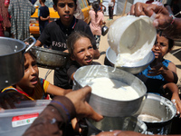 Displaced Palestinians are gathering to receive food cooked by a charity kitchen, amid food scarcity, as the Israel-Hamas conflict continues...