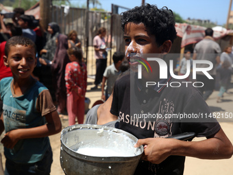 A Palestinian is carrying food cooked by a charity kitchen, amid shortages of aid supplies, as the conflict between Israel and Hamas continu...