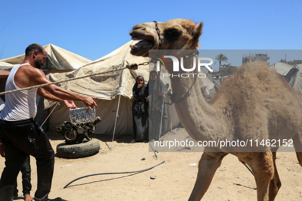 A Palestinian is carrying food cooked by a charity kitchen, amid shortages of aid supplies, as the conflict between Israel and Hamas continu...