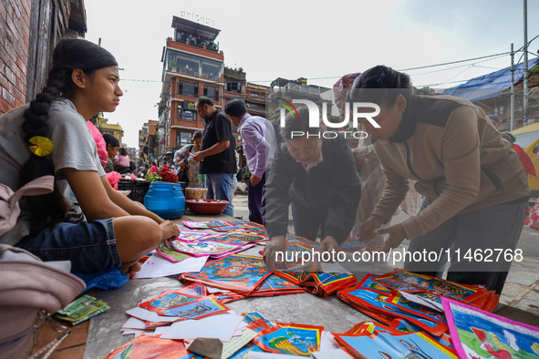 Vendors at a local market near the Patan Durbar Square, a UNESCO World Heritage Site, are selling pictures of the serpent deity ''Naag'' ahe...