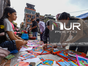 Vendors at a local market near the Patan Durbar Square, a UNESCO World Heritage Site, are selling pictures of the serpent deity ''Naag'' ahe...