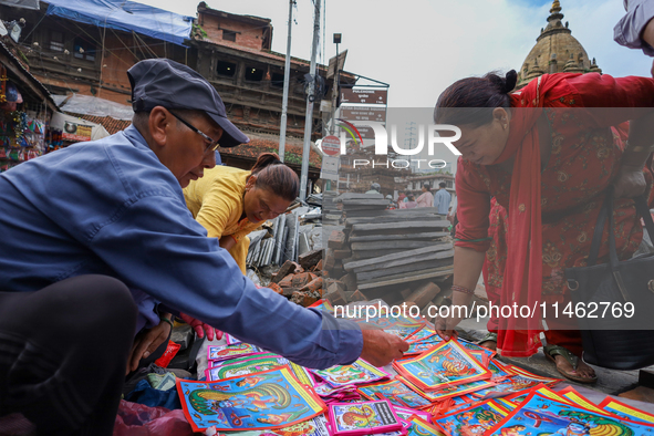 Vendors at a local market near the Patan Durbar Square, a UNESCO World Heritage Site, are selling pictures of the serpent deity ''Naag'' ahe...