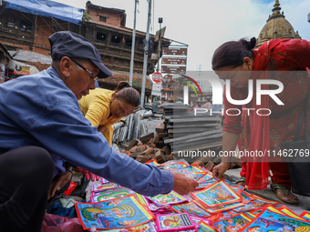 Vendors at a local market near the Patan Durbar Square, a UNESCO World Heritage Site, are selling pictures of the serpent deity ''Naag'' ahe...