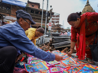 Vendors at a local market near the Patan Durbar Square, a UNESCO World Heritage Site, are selling pictures of the serpent deity ''Naag'' ahe...