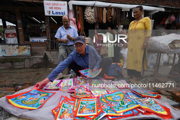 Vendors at a local market near the Patan Durbar Square, a UNESCO World Heritage Site, are selling pictures of the serpent deity ''Naag'' ahe...