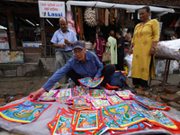 Vendors at a local market near the Patan Durbar Square, a UNESCO World Heritage Site, are selling pictures of the serpent deity ''Naag'' ahe...