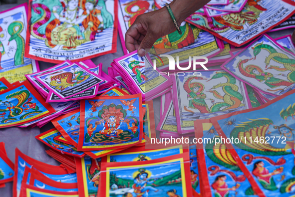 Vendors at a local market near the Patan Durbar Square, a UNESCO World Heritage Site, are selling pictures of the serpent deity ''Naag'' ahe...