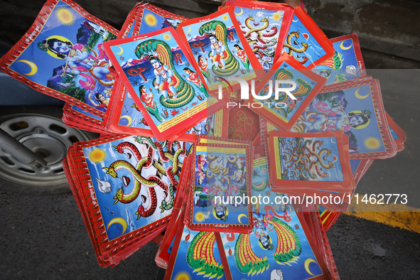 Vendors at a local market near the Patan Durbar Square, a UNESCO World Heritage Site, are selling pictures of the serpent deity ''Naag'' ahe...