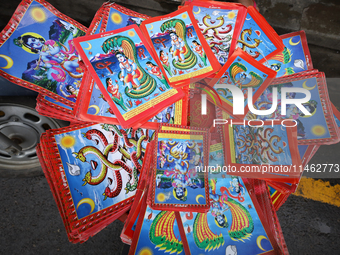 Vendors at a local market near the Patan Durbar Square, a UNESCO World Heritage Site, are selling pictures of the serpent deity ''Naag'' ahe...