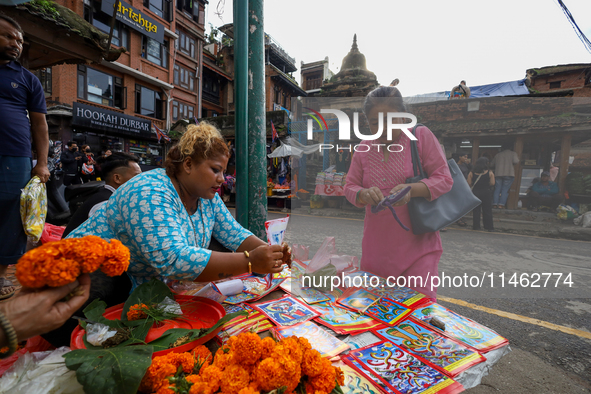 Vendors at a local market near the Patan Durbar Square, a UNESCO World Heritage Site, are selling pictures of the serpent deity ''Naag'' ahe...