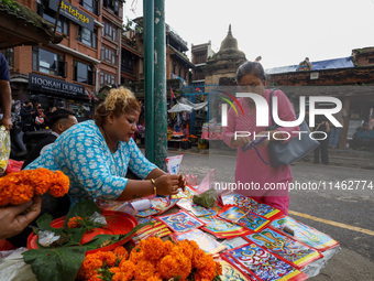 Vendors at a local market near the Patan Durbar Square, a UNESCO World Heritage Site, are selling pictures of the serpent deity ''Naag'' ahe...