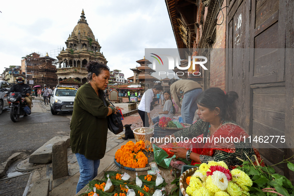 Vendors at a local market near the Patan Durbar Square, a UNESCO World Heritage Site, are selling pictures of the serpent deity ''Naag'' ahe...