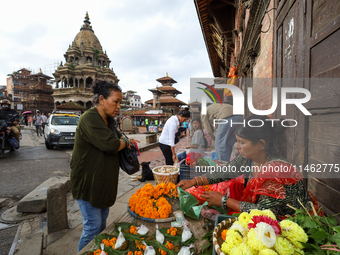 Vendors at a local market near the Patan Durbar Square, a UNESCO World Heritage Site, are selling pictures of the serpent deity ''Naag'' ahe...