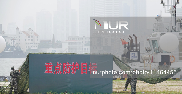 A professional defense mobilization support team is covering a camouflage net during a comprehensive defense mobilization exercise in Yantai...